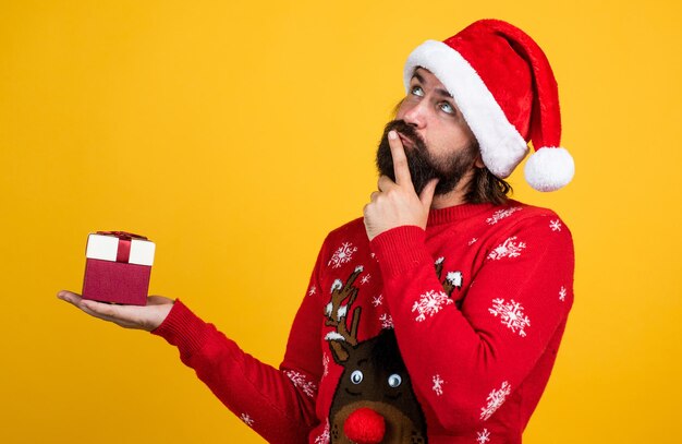 Fröhlicher bärtiger Mann im Weihnachtsmann-Kostüm feiert den Winterurlaub von Weihnachten und freut sich über Weihnachtsgeschenke, letzte Vorbereitung.