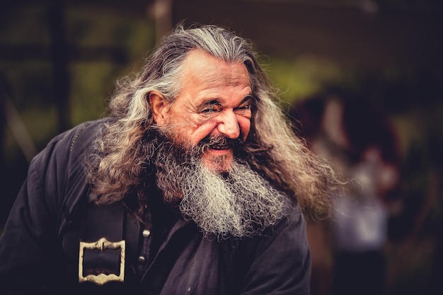 Fröhlicher bärtiger Mann mit langen Haaren