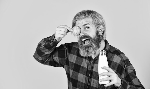 Fröhlicher Bauer isst Cookie-Dessert bärtiger Mann trinkt nützliche Milch mit Gebäck Lebkuchenplätzchen