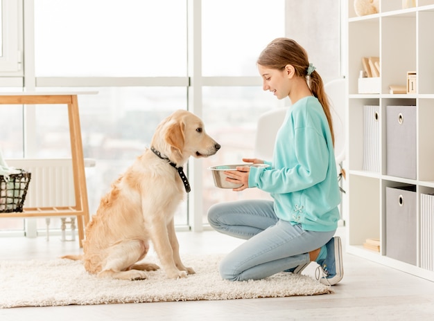 Fröhlicher Besitzer, der niedlichen Hund füttert