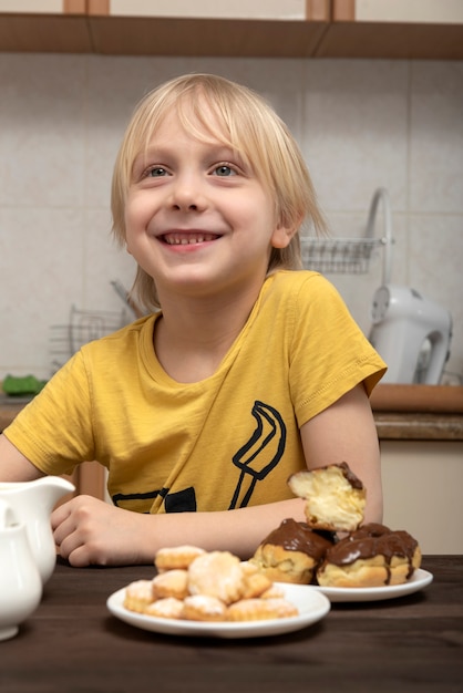 Fröhlicher blonder Junge bekam Nachtisch