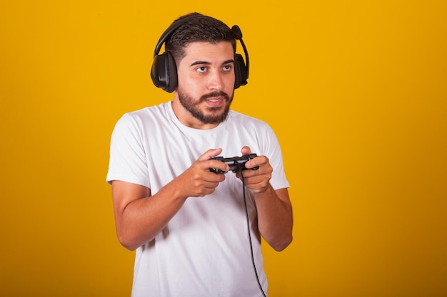 Fröhlicher brasilianischer Lateinamerikaner mit Headset und Videospielcontroller, der Emotionen genießt