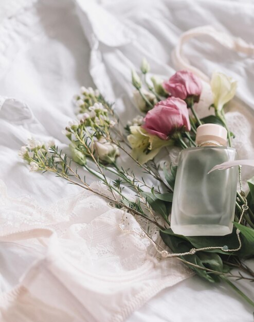 Fröhlicher Frauentag Stilvolle Dessous, Schmuck, Parfüm und Frühlingsblumen auf dem Hemd. Weiches, trendiges Bild