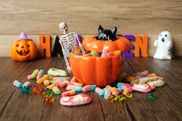 Fröhlicher Halloween-Tag mit Geisterbonbons, Kerze, Kürbis, Jack O-Laterne und dekorativ (selektiver Fokus). Trick or Threat, Hallo Oktober, Herbstherbst, Fest-, Party- und Urlaubskonzept