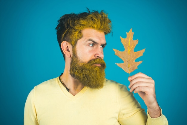 Fröhlicher Herbstmann im Park auf lokalisiertem Blau