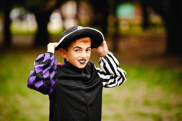 Fröhlicher Junge mit roten Haaren im Anzug für Halloween