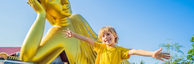 Fröhlicher Junge Tourist auf dem Hintergrund des liegenden Buddha-Statuen-Banners im Langformat