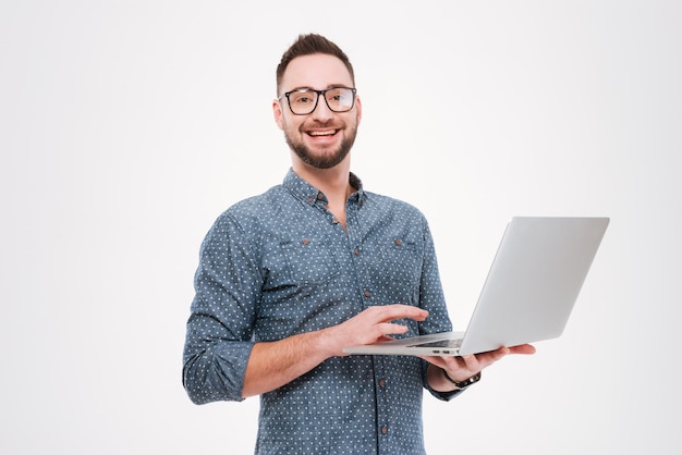 Fröhlicher junger bärtiger Mann mit Laptop