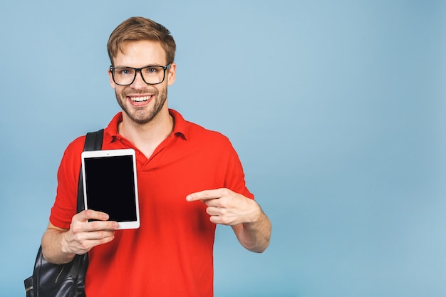 Fröhlicher junger Reise- oder Studentenmann im lässigen Zeigen auf Tablett mit leerem Bildschirm