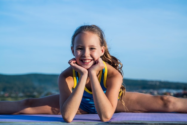 Fröhlicher Kindersportler oder Turner in Split auf Himmelshintergrund flexibel