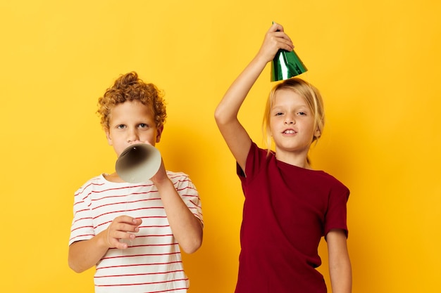 Fröhlicher Kinderurlaubsspaß mit Kappen auf dem Kopf, isolierter Hintergrund Foto in hoher Qualität