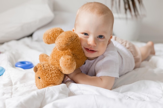 Fröhlicher kleiner Junge, der mit Spielzeug auf Decke, Teddybär, Gesundheit, Banner, Karte spielt