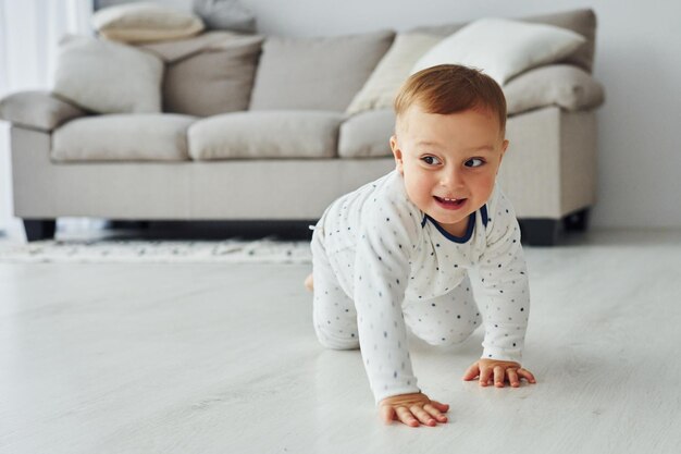 Fröhlicher kleiner Junge hat Spaß Interieur und Design eines schönen modernen Schlafzimmers tagsüber