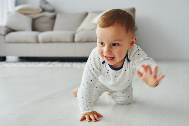 Fröhlicher kleiner Junge hat Spaß Interieur und Design eines schönen modernen Schlafzimmers tagsüber