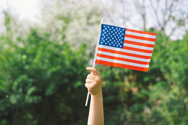 Fröhlicher kleiner patriotischer Junge mit amerikanischer Flagge USA feiern den 4. Juli Glücklicher Unabhängigkeitstag