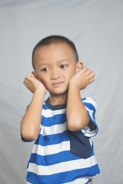Fröhlicher lächelnder Junge, der im Studio fotografiert