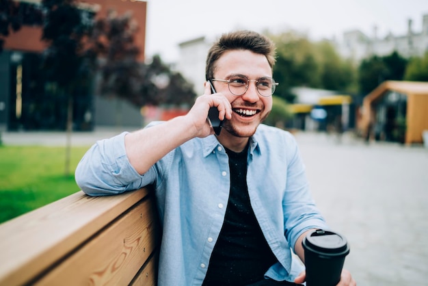 Fröhlicher Mann, der Handy auf der Straße anruft