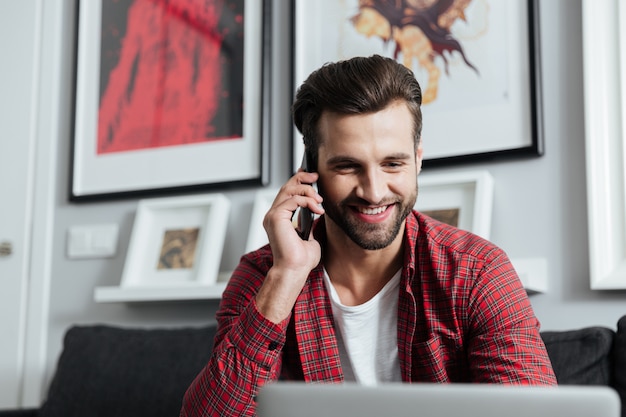 Fröhlicher Mann, der per Telefon spricht.