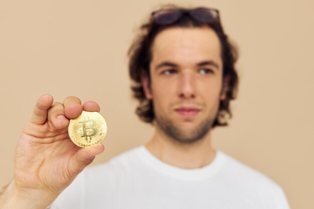 Fröhlicher Mann in einem weißen T-Shirt mit Bitcoin-Kryptowährung isoliertem Hintergrund