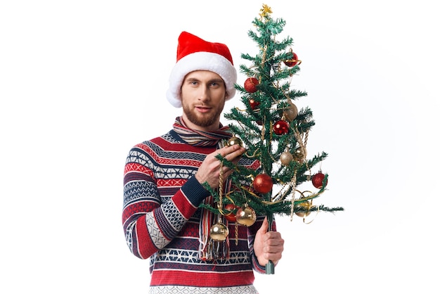 Fröhlicher Mann mit einem Baum in seinen Händen verziert Feiertagsspaß isolierten Hintergrund