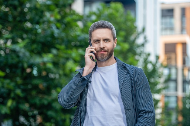 Fröhlicher Mann ruft auf dem Smartphone an. Foto des Mannes ruft auf dem Smartphone an und spricht