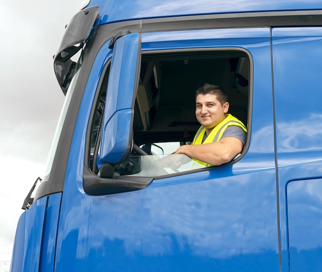 Fröhlicher Mann sitzt im LKW am Lenkrad