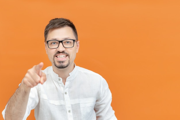 Fröhlicher Mann über isoliertem Hintergrund, der mit glücklichem und lustigem Gesicht mit den Fingern auf die Kamera zeigt