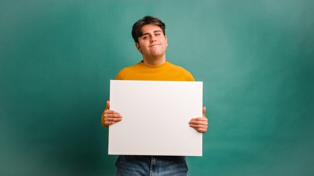 Foto fröhlicher mann zeigt ein leeres banner im studio