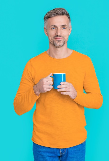 Fröhlicher reifer Mann in der Kaffeepause auf Hintergrundfoto des reifen Mannes in der Kaffeepause