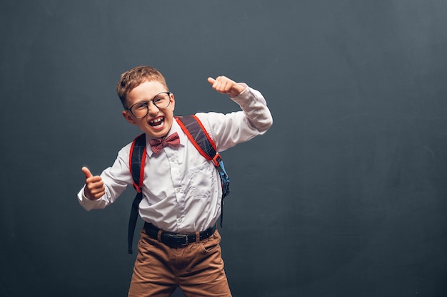 Fröhlicher Schuljunge in Brille und Uniform