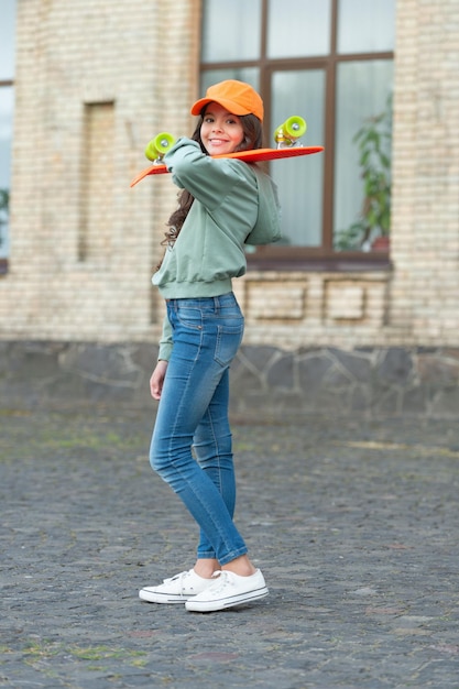 Fröhlicher Teenie-Skater mit Skateboard-Mädchen im Freien mit Penny-Board-Hipster-Mädchen mit Longboard