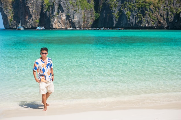 Foto fröhlicher touristenmann am maya bay beach auf der insel phi phi krabi thailand wahrzeichen reiseziel südostasien reiseurlaub und urlaubskonzept