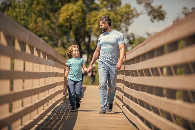 Fröhlicher Vater, der mit seinem Sohn im Freien Freundschaft geht