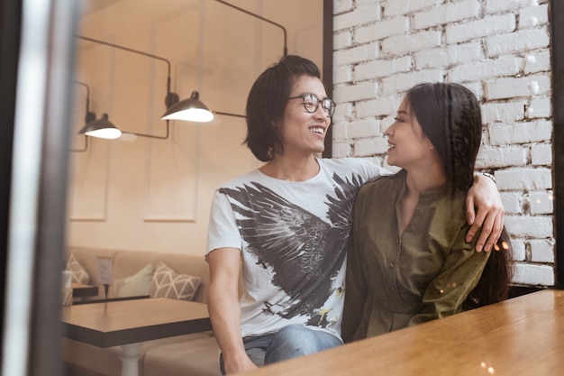 Fröhliches asiatisches junges Liebespaar im Café.