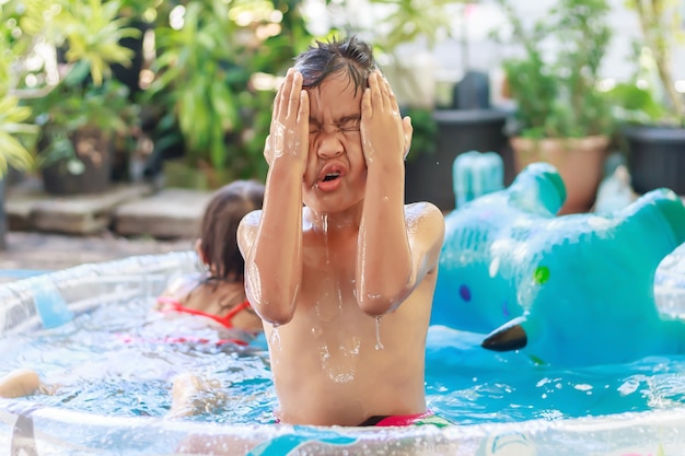 Foto fröhliches asiatisches kind, das im wasserpool spielt und schwimmt sommersaison und kinderkonzept