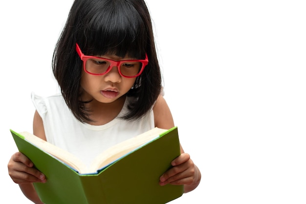 Fröhliches asiatisches kleines Vorschulmädchen mit roter Brille, das ein grünes Buch auf Weiß hält und las