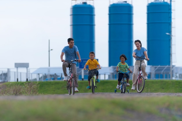 Fröhliches Familienradfahren auf Fahrrädern im Freien, aktive Eltern mit Kindern haben Spaß, Familiensport und Fitness, Urlaub, Entspannung im Grünen