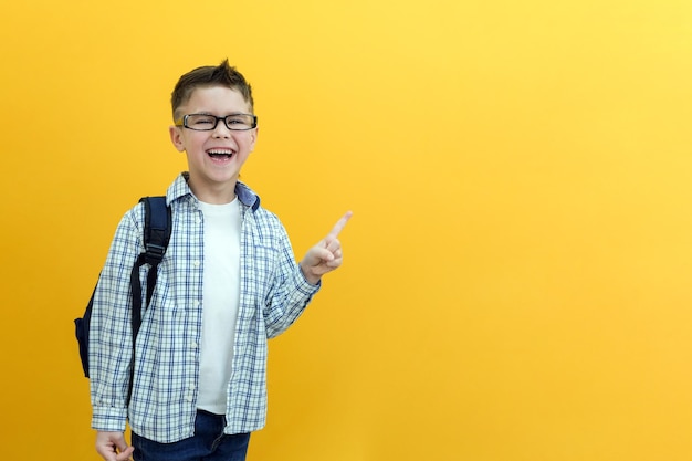 Fröhliches glückliches kind zeigt platz für text kopieren lächelnder enthusiastischer schuljunge in einem karierten hemd, das sich zeigt
