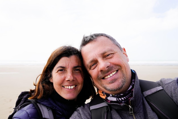 Fröhliches, glückliches Touristenpaar, das im Urlaub am Sandstrand Meer ein Selfie macht