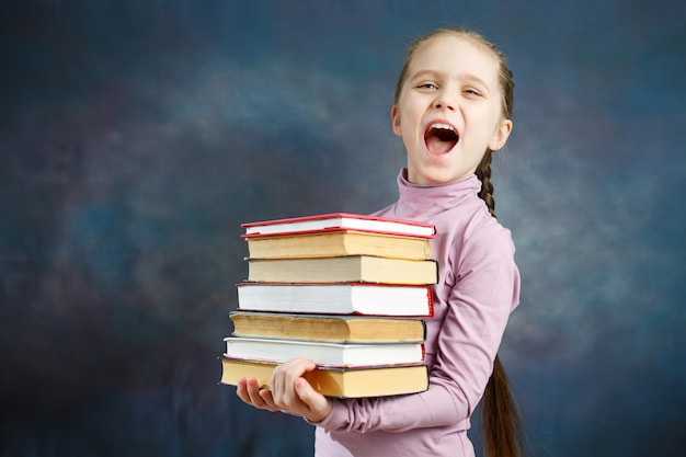 Fröhliches Grundschulmädchen halten Buchbündel