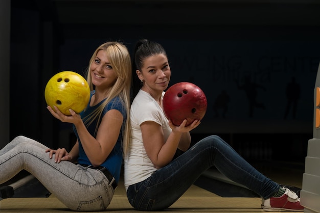 Fröhliches junges Paar mit Bowlingkugel