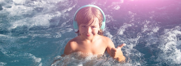 Fröhliches Kind, das an heißen Sommertagen im Außenpool spielt Kinder lernen, im Wasser zu schwimmen Kind