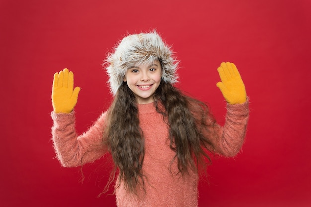 Fröhliches Kind, das bequeme warme Kleidung für kalte Wettervorhersage im Winterweihnachtsurlaub trägt