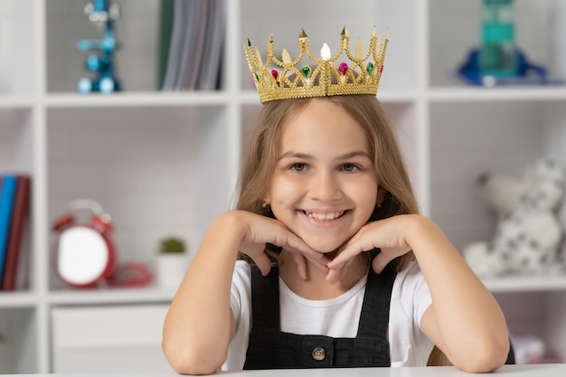 Fröhliches Kind in Queen Crown im Schulklassenzimmer