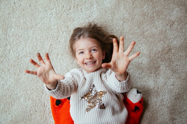 Fröhliches kleines Kind auf dem Boden mit Kitzeln