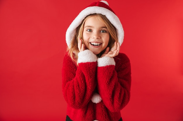 Fröhliches kleines Mädchen, das Weihnachtskostüm trägt, das isoliert steht