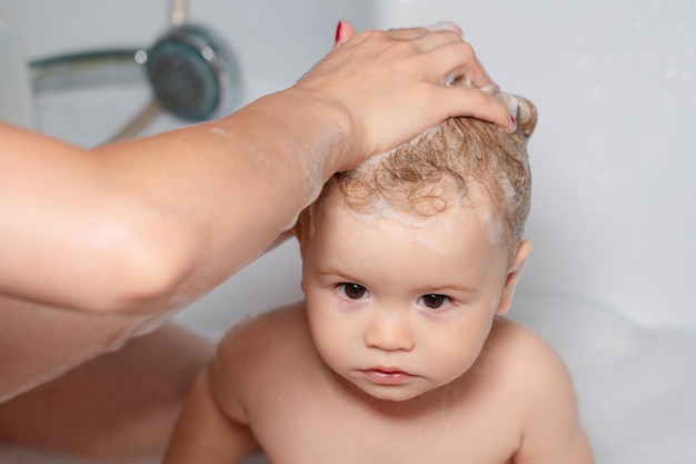 Fröhliches lustiges Baby in der Badewanne gebadet Kleinkind in der Dusche lustiges Baby in der Dusche