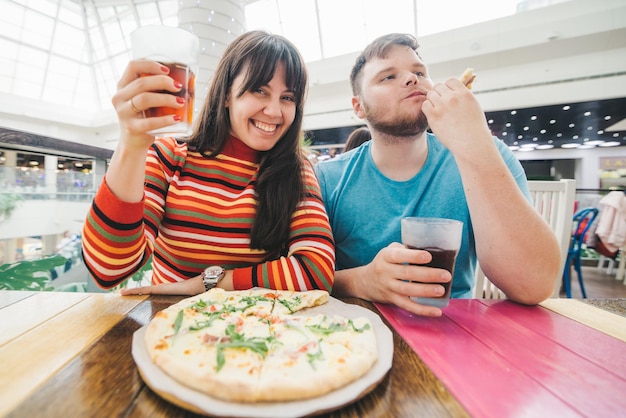 Fröhliches Paar sitzt im Café und isst Pizza Ungarn