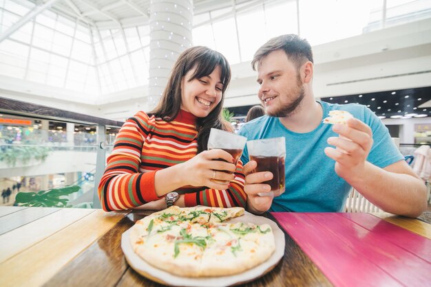 Fröhliches Paar sitzt im Café und isst Pizza Ungarn