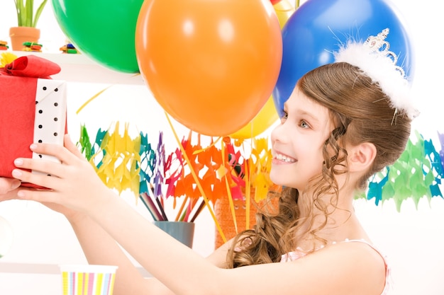 fröhliches Partygirl mit Luftballons und Geschenkbox